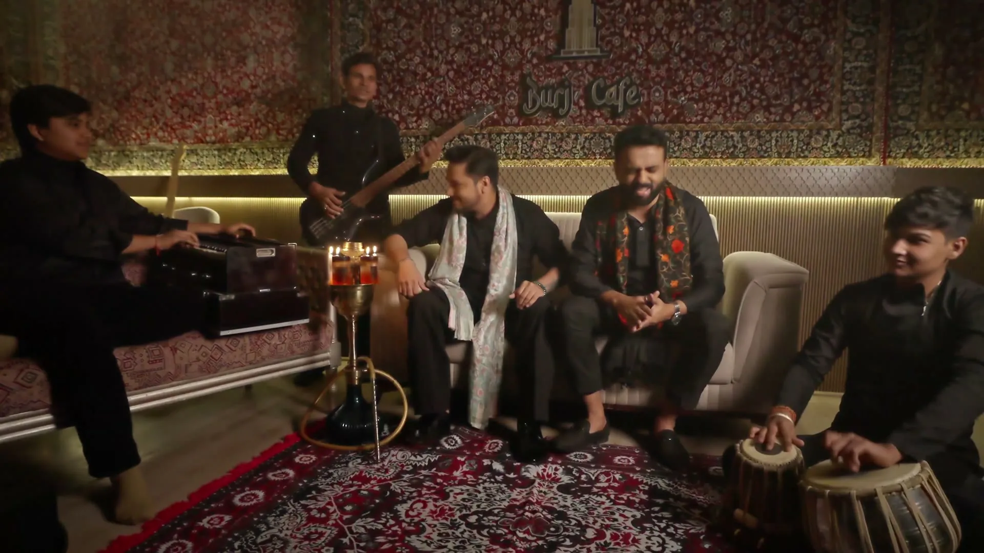 The full qawwali ensemble on the carpet: harmonium, bass, tabla and the two singers.