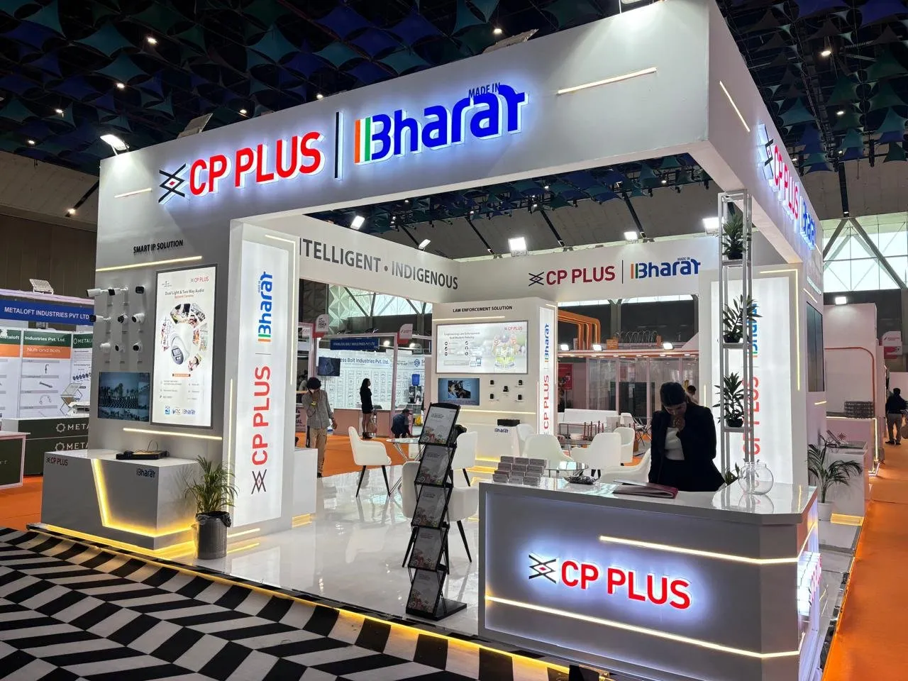 CP Plus corner booth with a lit sign and orange floor