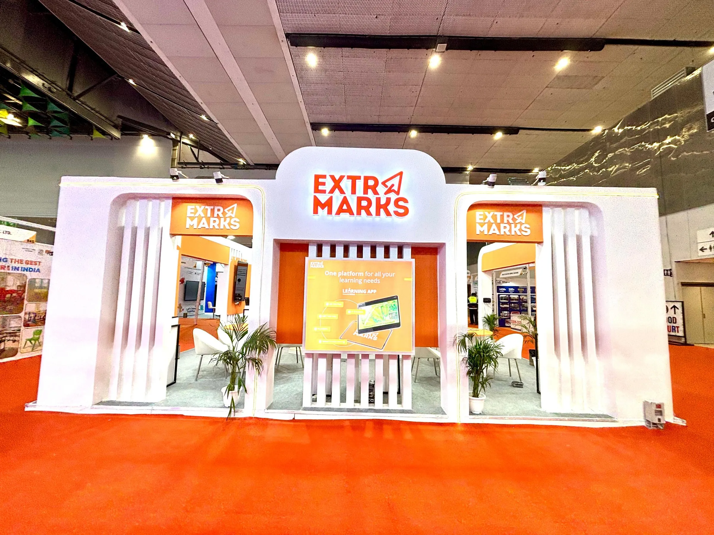 Extramarks booth seen from a slight angle with the orange carpet