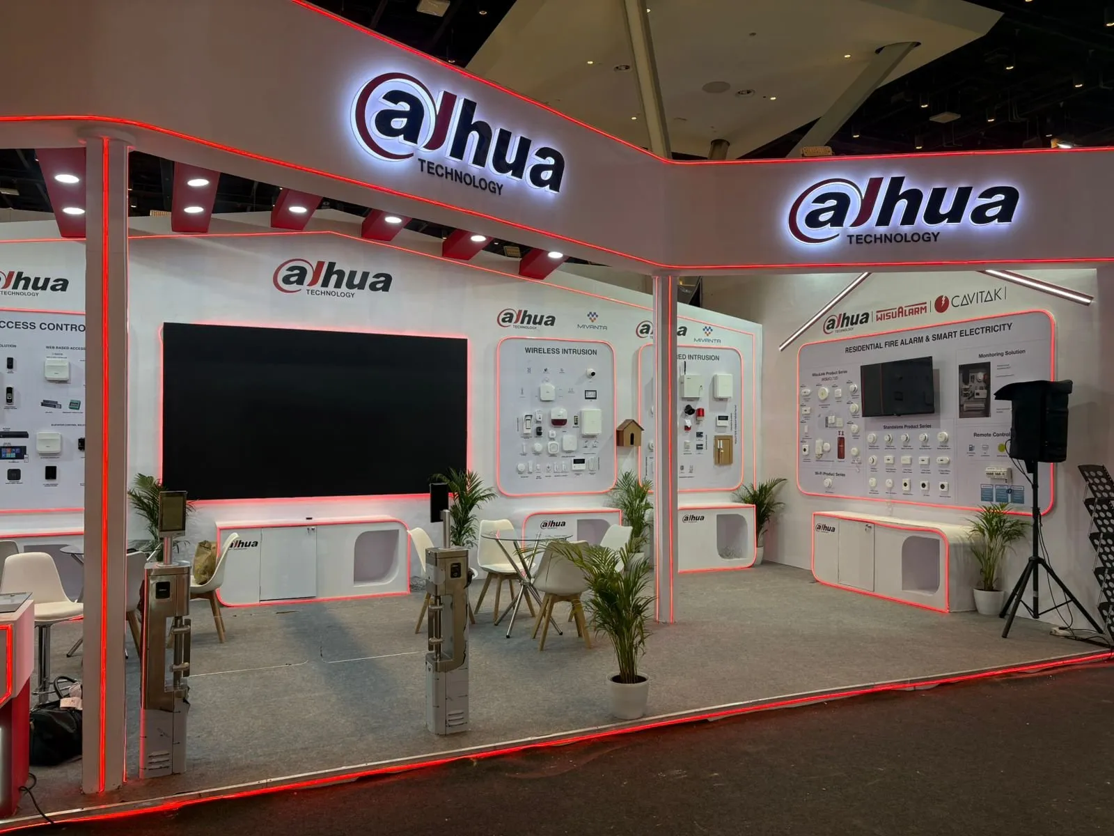 Wide view of the booth with a large screen and seating