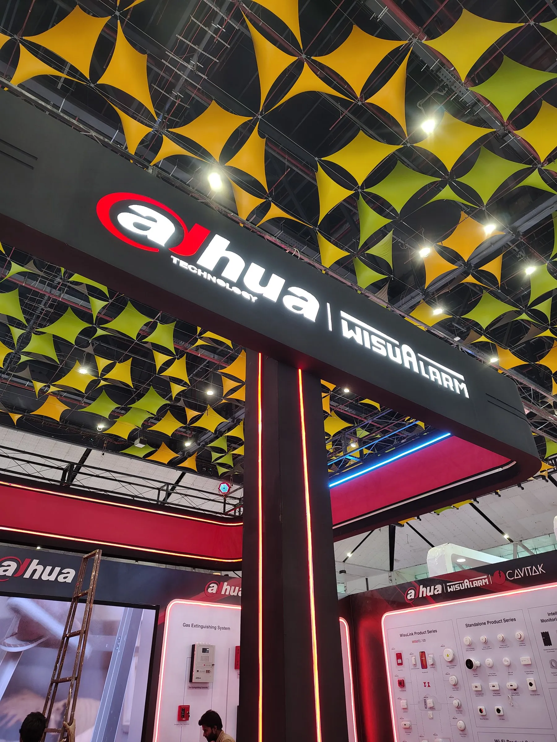 Low-angle view of the black and red Dahua WisuAlarm fascia under a yellow and black ceiling