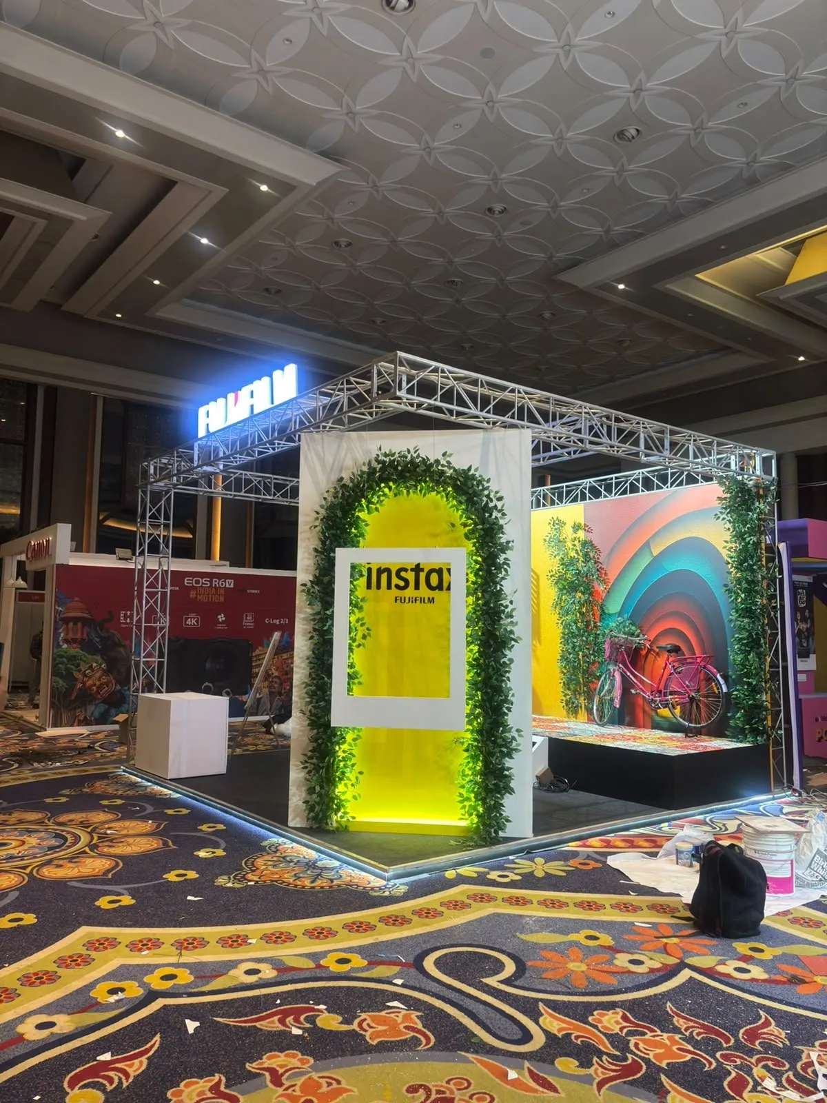 Yellow Instax arch wrapped in greenery