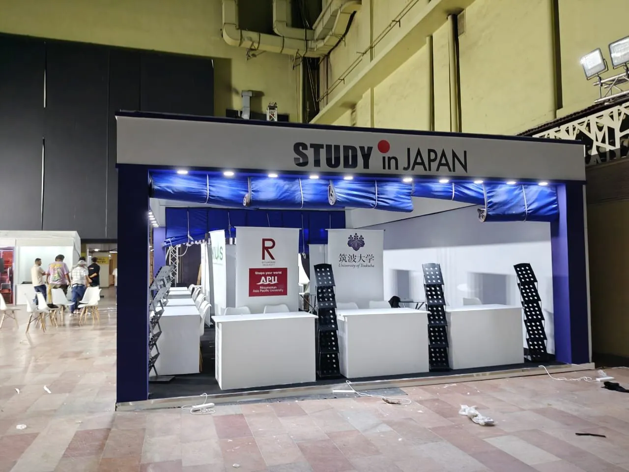 Study in Japan university stand with blue canopy, counters and brochure racks